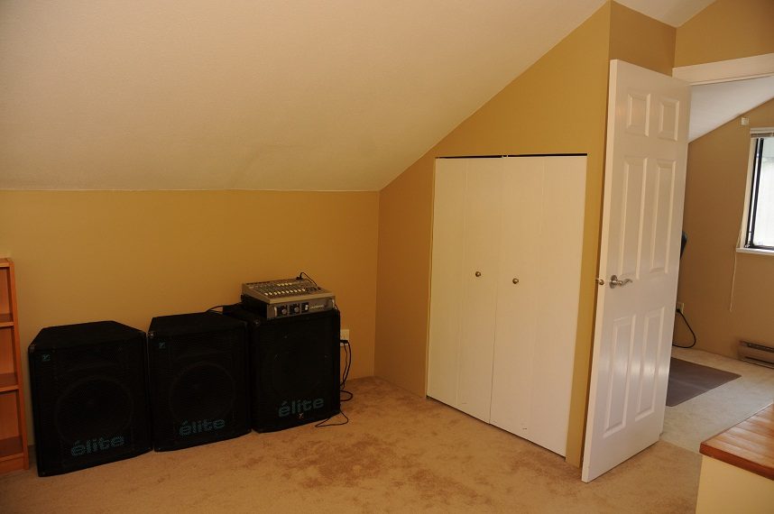 Living room with large speakers and closet. - 5591 Huckleberry Place, North Vancouver