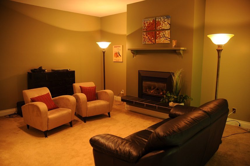 Living room with cozy seating, fireplace, and warm lighting. - 5591 Huckleberry Place, North Vancouver
