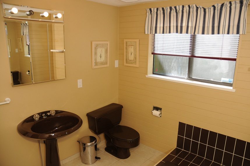 Bathroom with dark countertop, toilet, and striped window treatment. - 5591 Huckleberry Place, North Vancouver