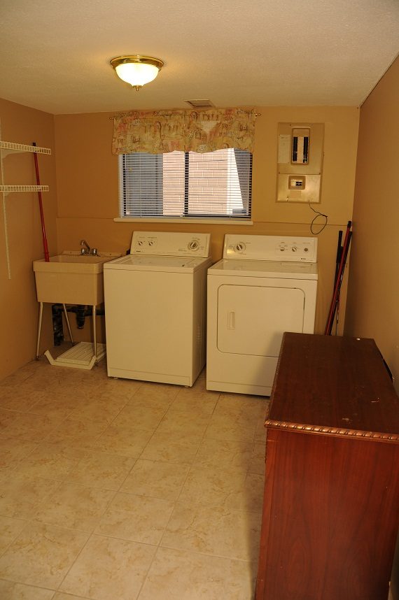 Laundry room with white appliances, tiled floor, and window with blinds. - 5591 Huckleberry Place, North Vancouver