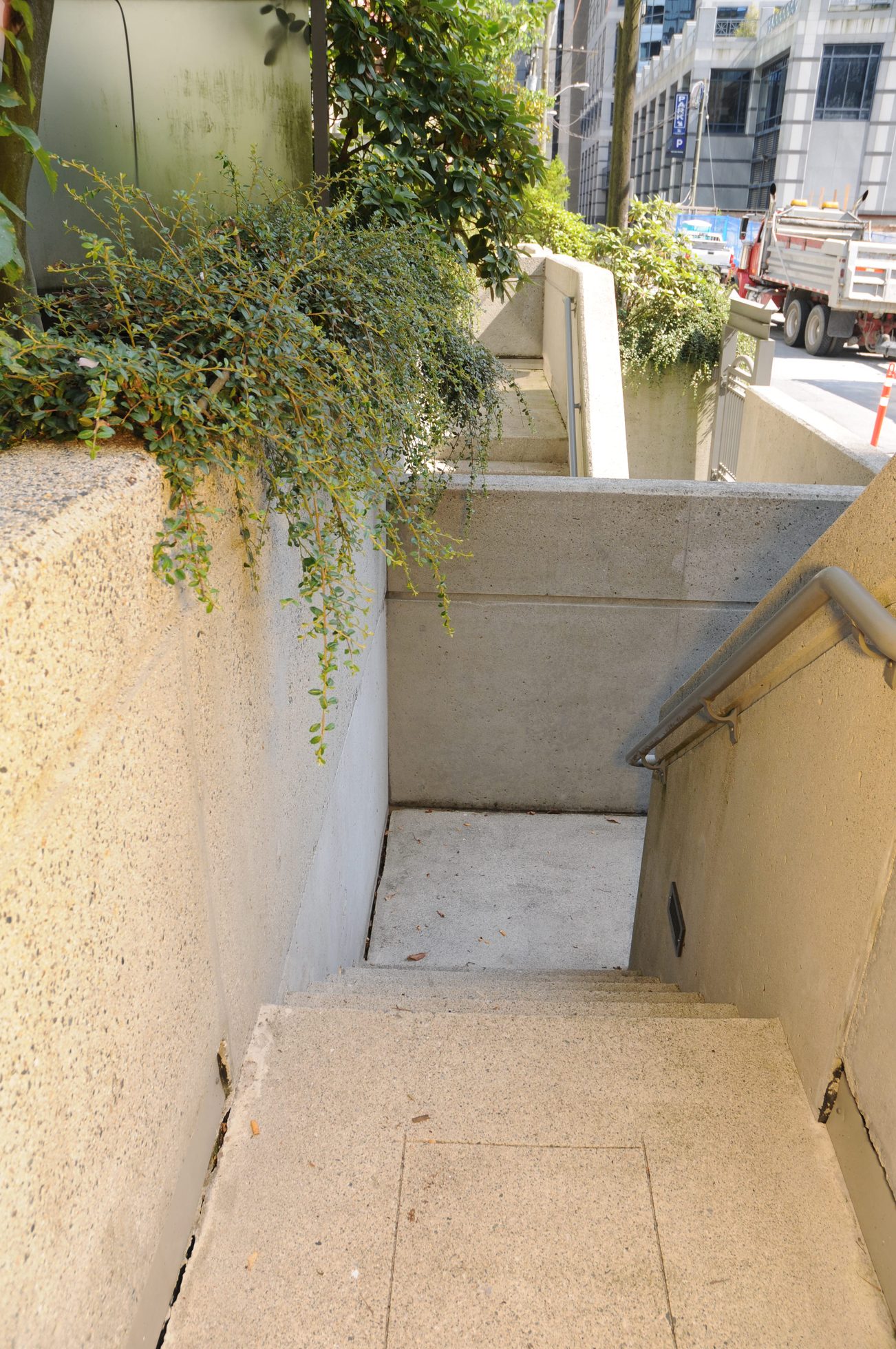 Staircase leading to a private entrance with concrete steps and greenery. - 211 - 1166 Melville St, Vancouver Downtown