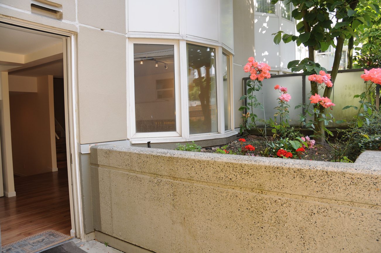 Bright living room with bay window and flower garden. - 211 - 1166 Melville St, Vancouver Downtown