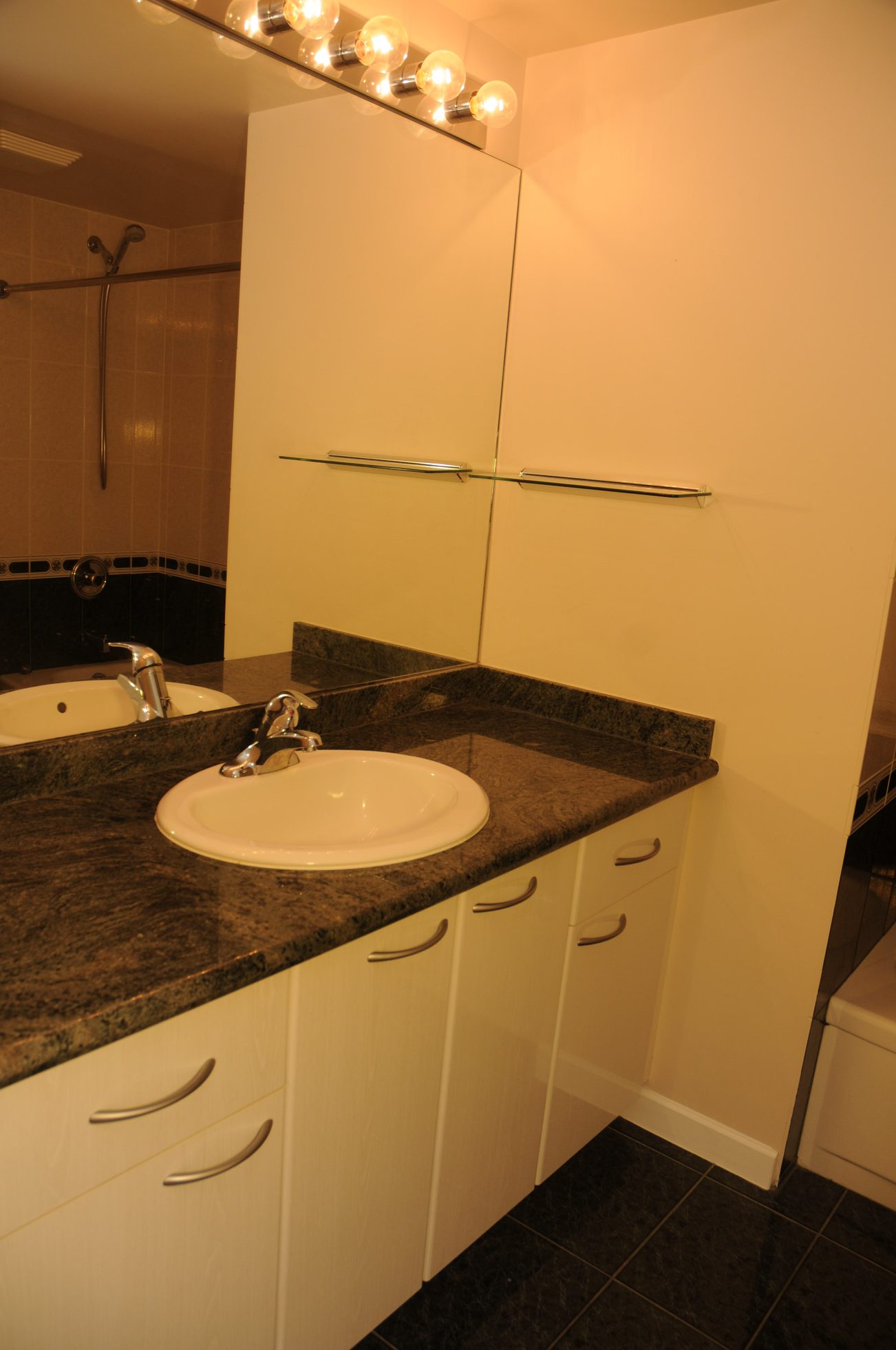 Bathroom with granite countertop and white cabinets. - 211 - 1166 Melville St, Vancouver Downtown