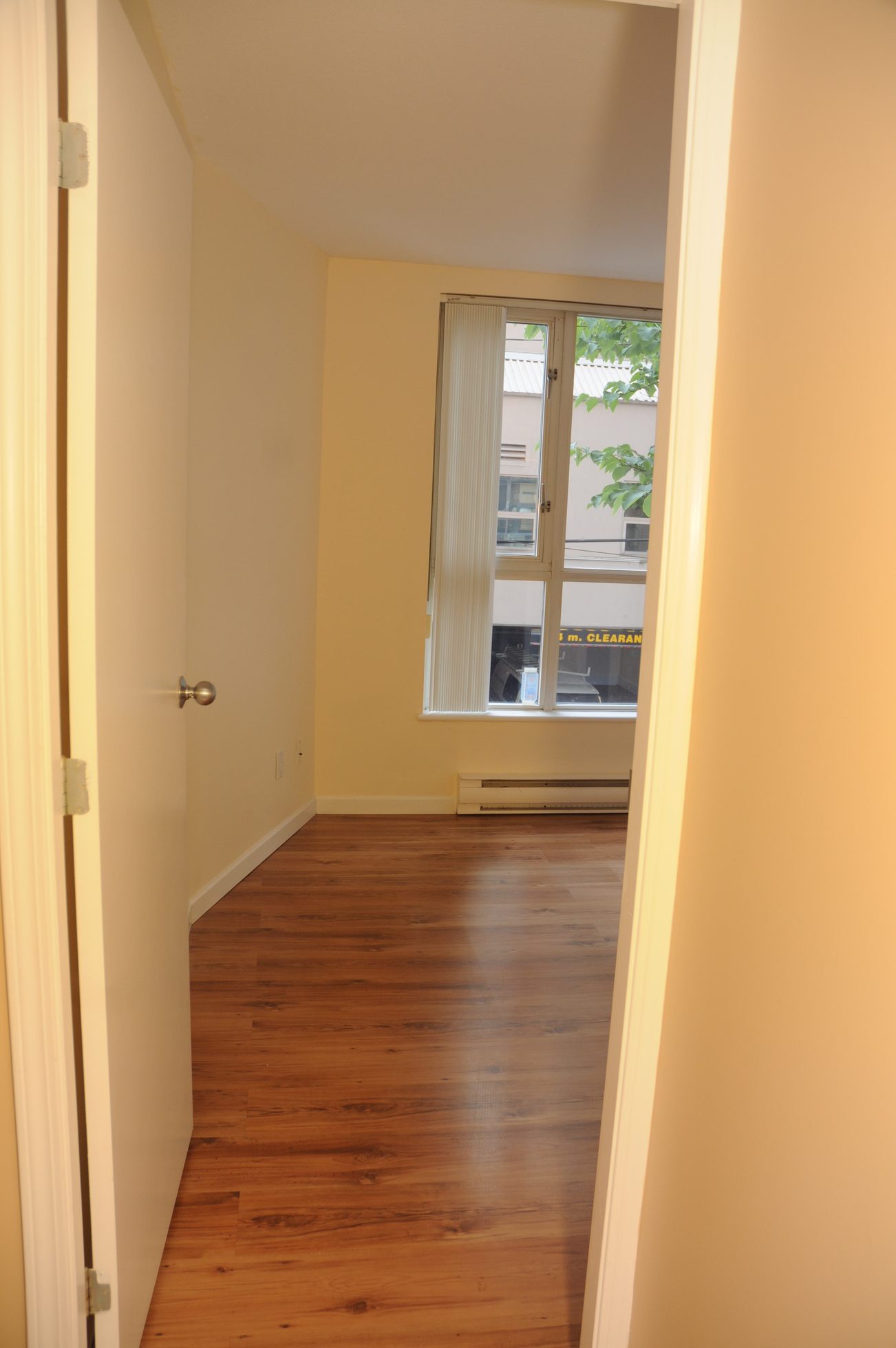 Bright bedroom with hardwood floors and a view of the city. - 211 - 1166 Melville St, Vancouver Downtown