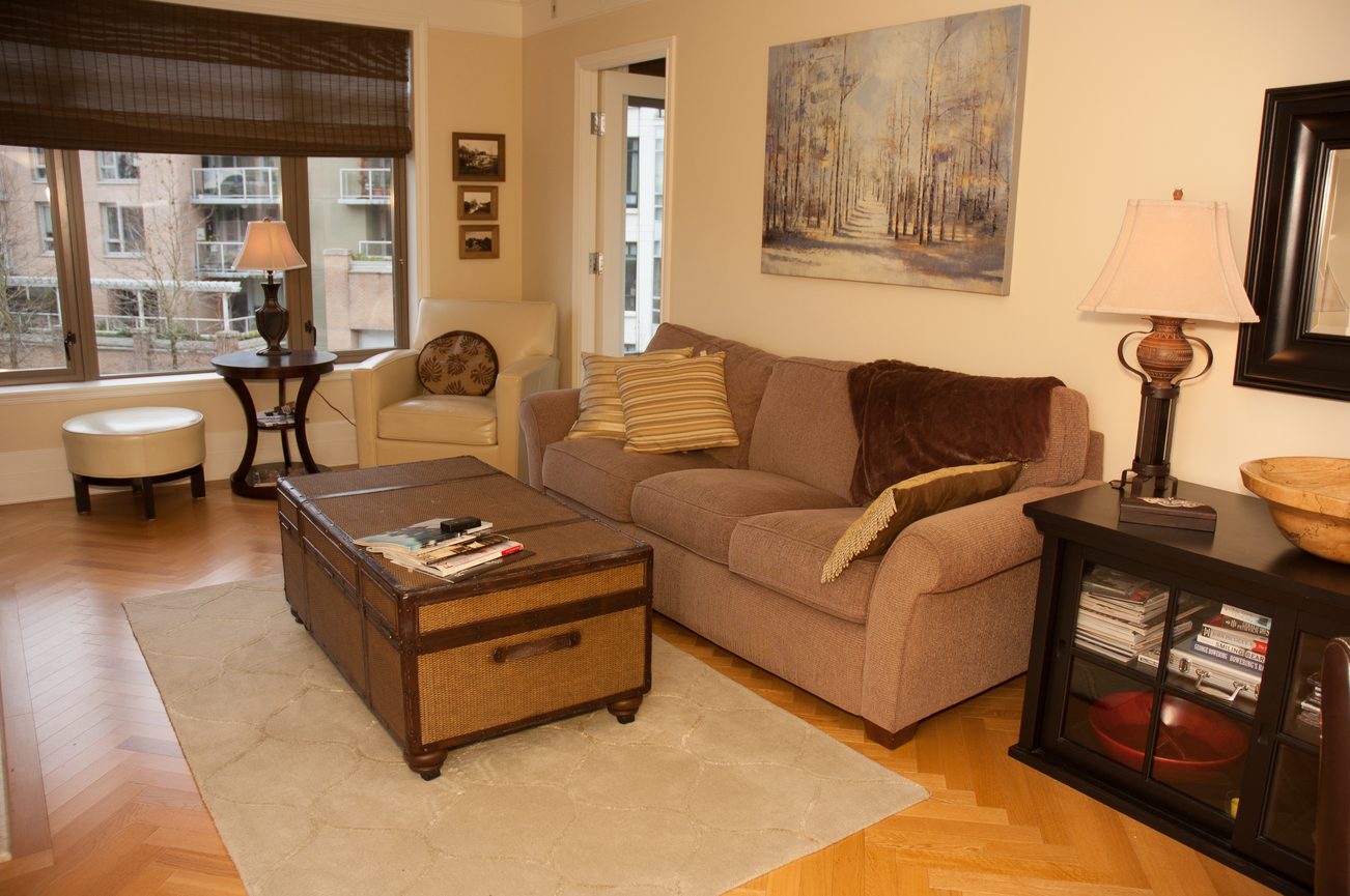 Furnished living room with hardwood floors, city view, and cozy sectional sofa. - 305-533 Waters edge crescent, West Vancouver