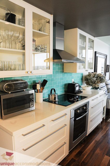Bright kitchen with teal backsplash, white cabinets, and hardwood floors. - 1802- 2055 Pendrell, Vancouver Downtown