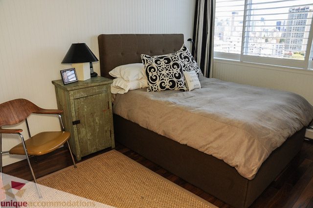 Bright bedroom with city view, hardwood floors, and a cozy bed setup. - 1802- 2055 Pendrell, Vancouver Downtown
