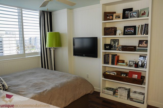 Bright living room with city view, modern decor, and built-in shelving. - 1802- 2055 Pendrell, Vancouver Downtown