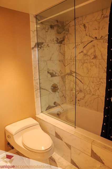 Furnished bathroom with marble tiles and a glass shower. - 1802- 2055 Pendrell, Vancouver Downtown