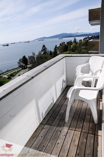 Bright balcony with wooden deck, white chairs, and stunning city view. - 1802- 2055 Pendrell, Vancouver Downtown