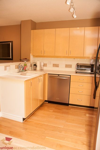 Bright kitchen with light wood cabinets, stainless steel dishwasher, and hardwood floors. - 402- 2680 West 4th Ave PH2, Vancouver West Side