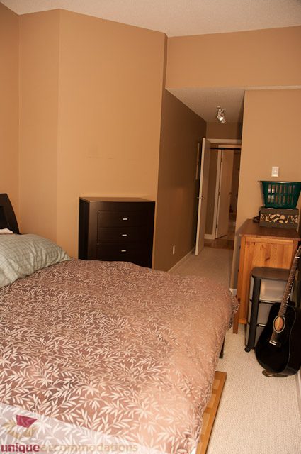 Furnished 1-bedroom with a neatly made bed, wooden nightstand, and a guitar in the corner. - 402- 2680 West 4th Ave PH2, Vancouver West Side