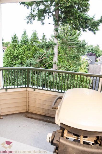 Furnished balcony with outdoor furniture and a view of trees and buildings. - 402- 2680 West 4th Ave PH2, Vancouver West Side