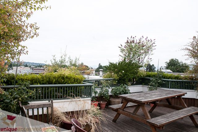 Furnished patio with wooden picnic tables and city view. - 402- 2680 West 4th Ave PH2, Vancouver West Side