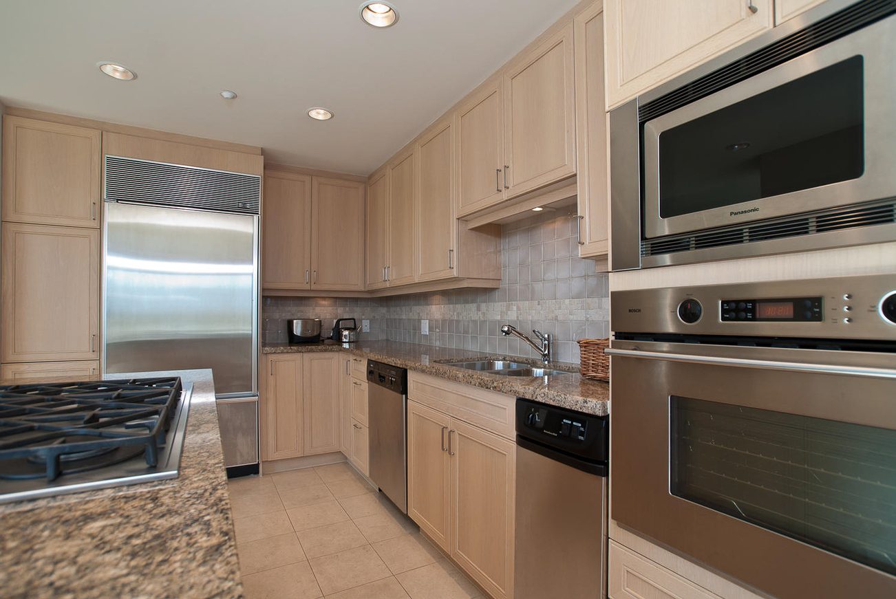 Bright kitchen with granite countertops, stainless steel appliances, and light wood cabinets. - 603 - 1717 Bayshore Drive, Vancouver Downtown