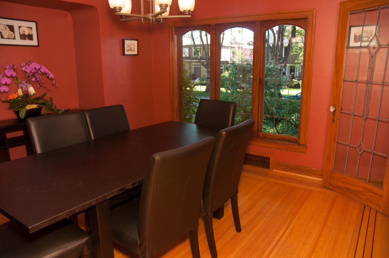 Dining room with hardwood floors, large bay window, and a wooden table with black chairs. - 3249 West 36th Ave, Vancouver West Side