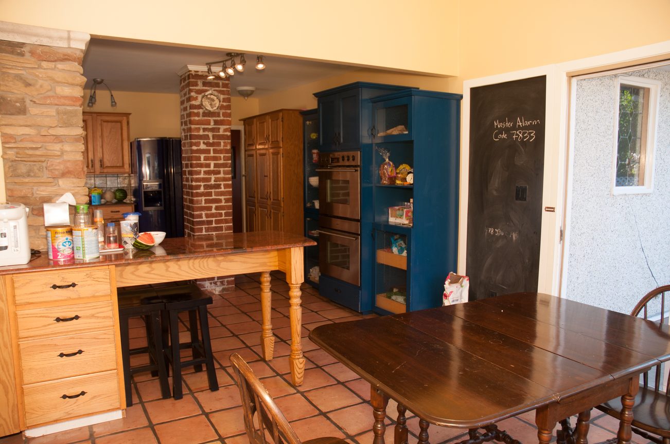 Bright kitchen with wooden countertops and blue cabinetry, open to a dining area with tiled floors. - 3249 West 36th Ave, Vancouver West Side