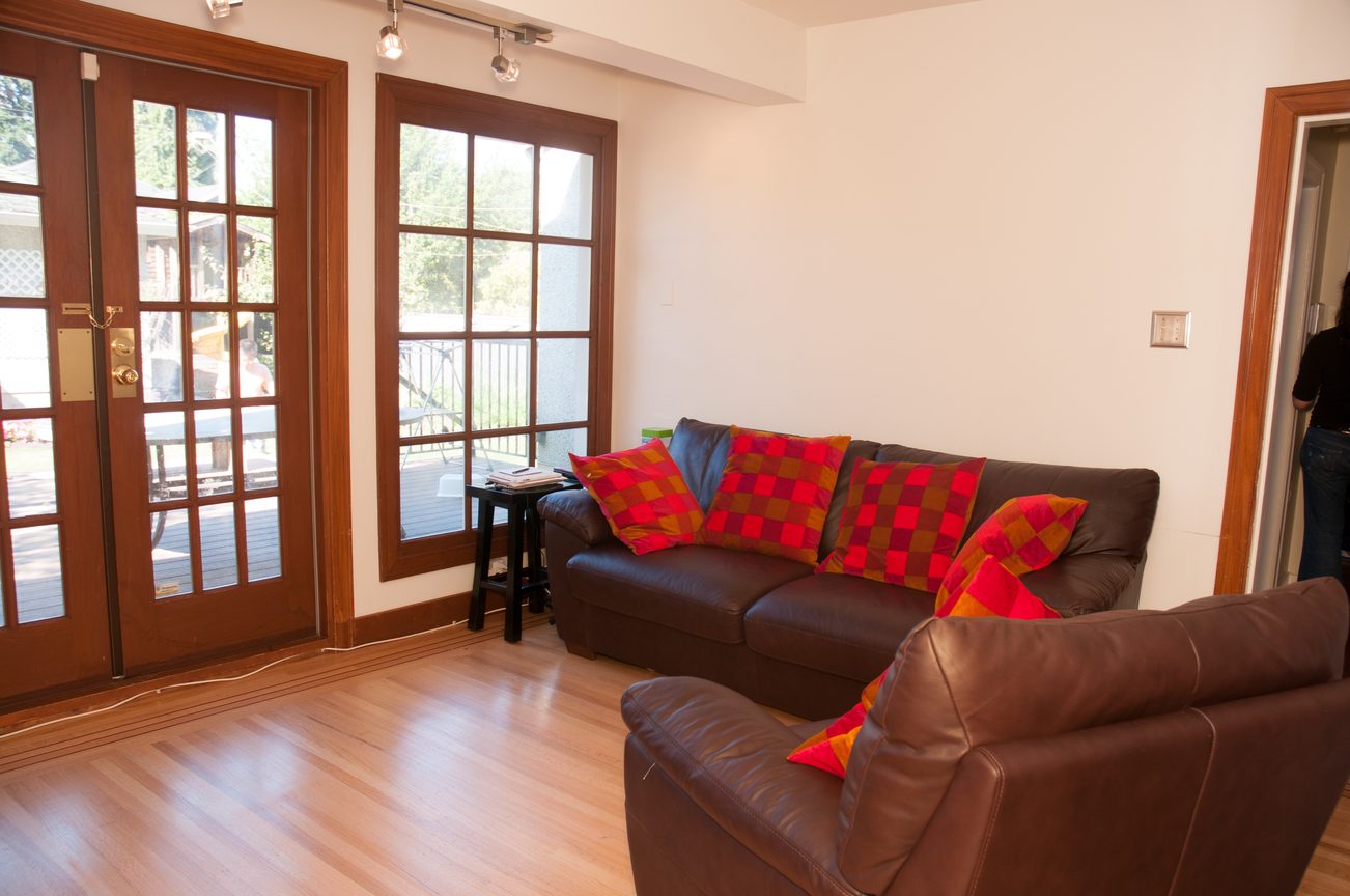 Bright living room with hardwood floors, leather couches, and colorful pillows. - 3249 West 36th Ave, Vancouver West Side