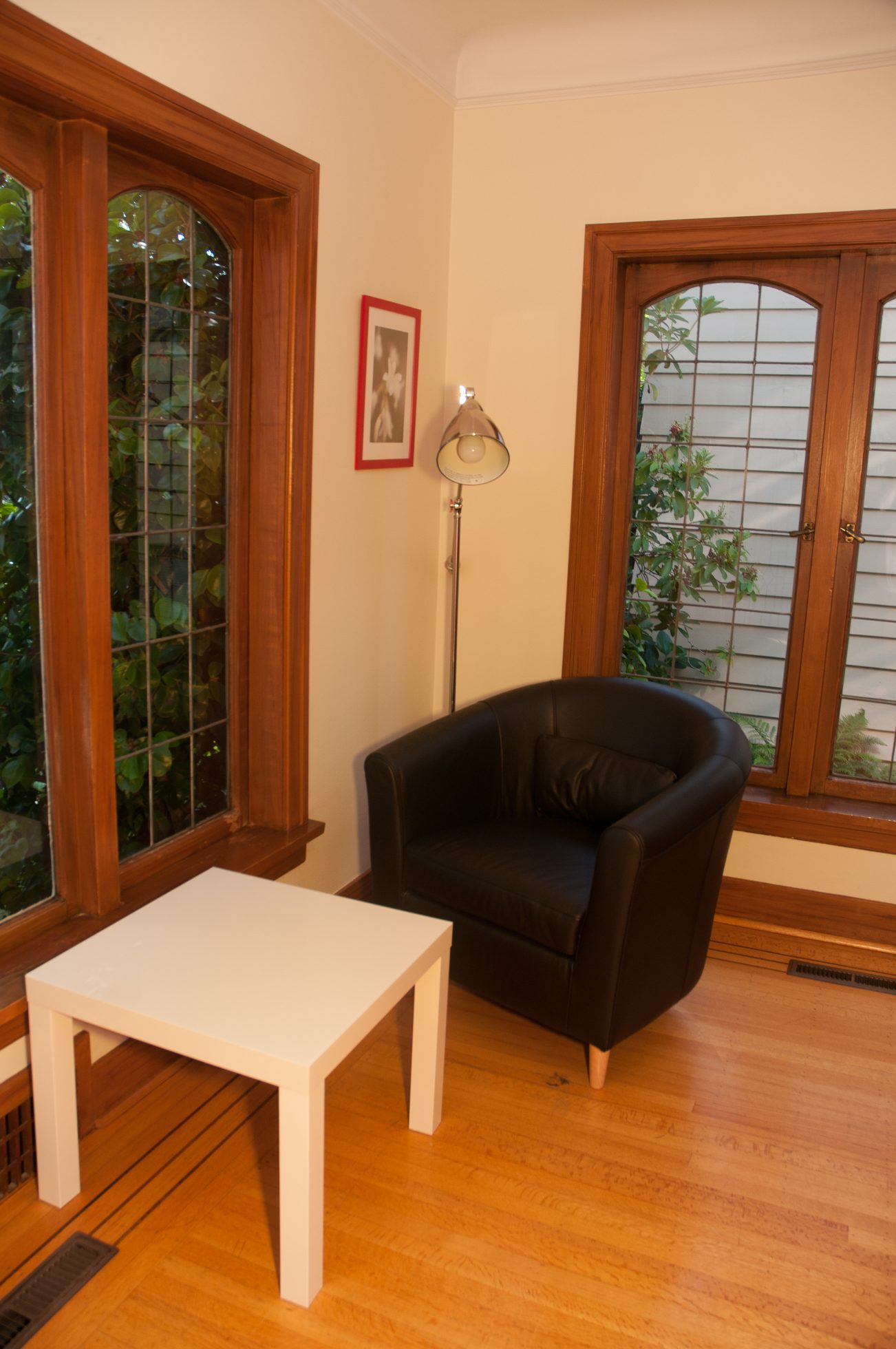 Bright living room with hardwood floors, a black leather armchair, and a white coffee table. - 3249 West 36th Ave, Vancouver West Side