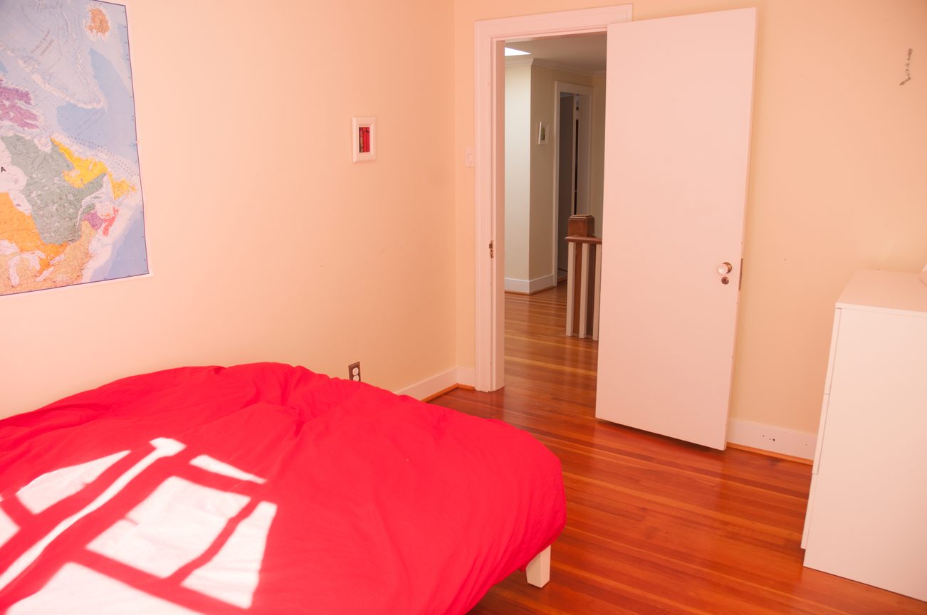 Bright bedroom with red bedding and hardwood floors. - 3249 West 36th Ave, Vancouver West Side