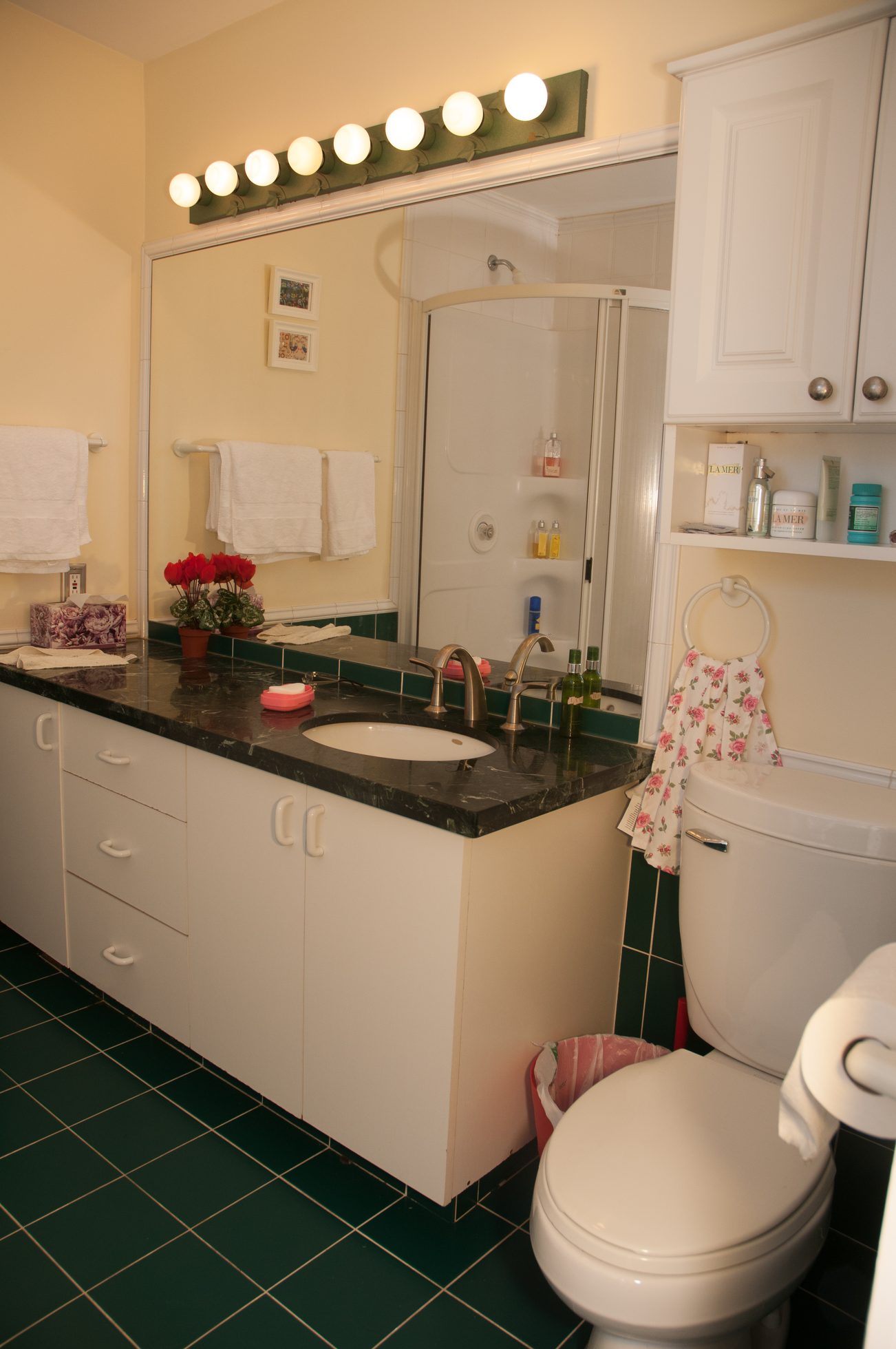 Bright bathroom with dark green marble countertops and white cabinets. - 3249 West 36th Ave, Vancouver West Side