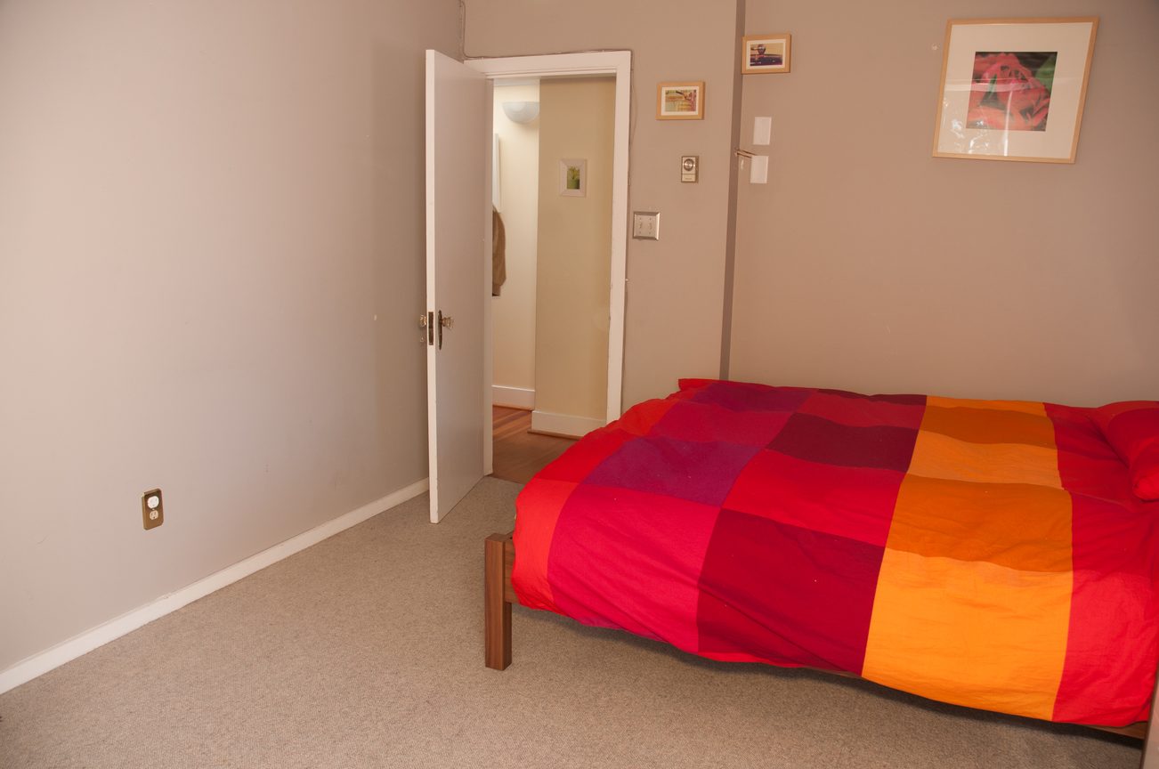 Bright bedroom with colorful bedding and a view down the hallway. - 3249 West 36th Ave, Vancouver West Side