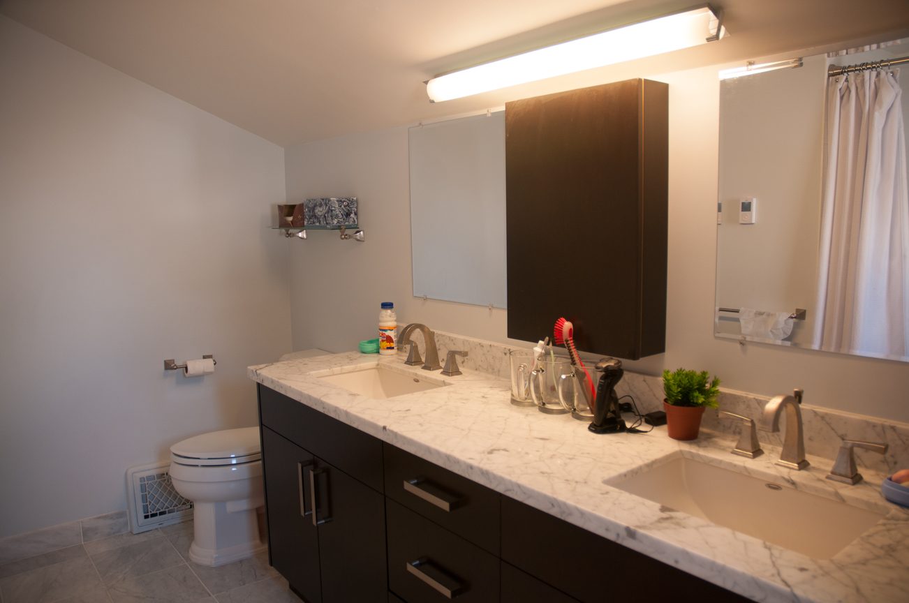 Modern bathroom with marble countertops and a dual-sink setup. - 3249 West 36th Ave, Vancouver West Side