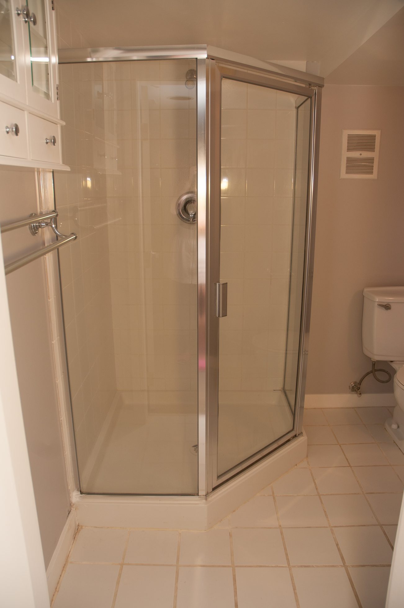 Bathroom with corner shower and white cabinetry. - 3249 West 36th Ave, Vancouver West Side