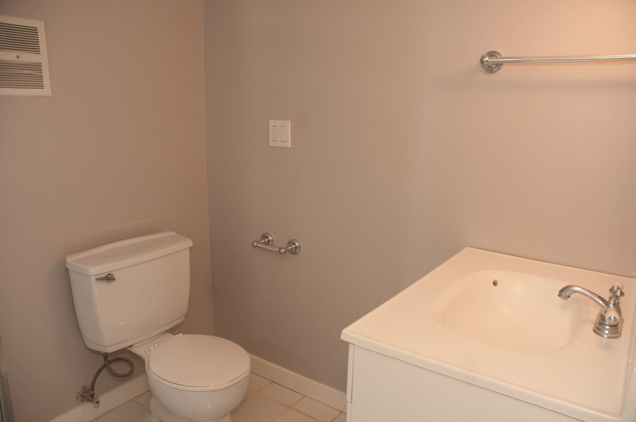 Bright bathroom with white fixtures and a grab bar. - 3249 West 36th Ave, Vancouver West Side