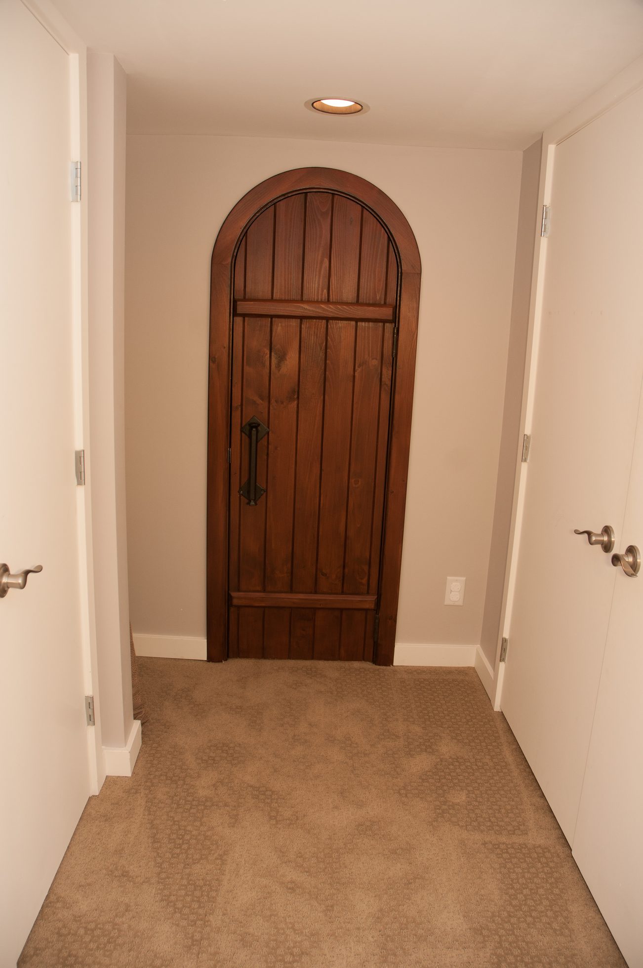 Entryway with arched wooden door and carpeted floor. - 3249 West 36th Ave, Vancouver West Side