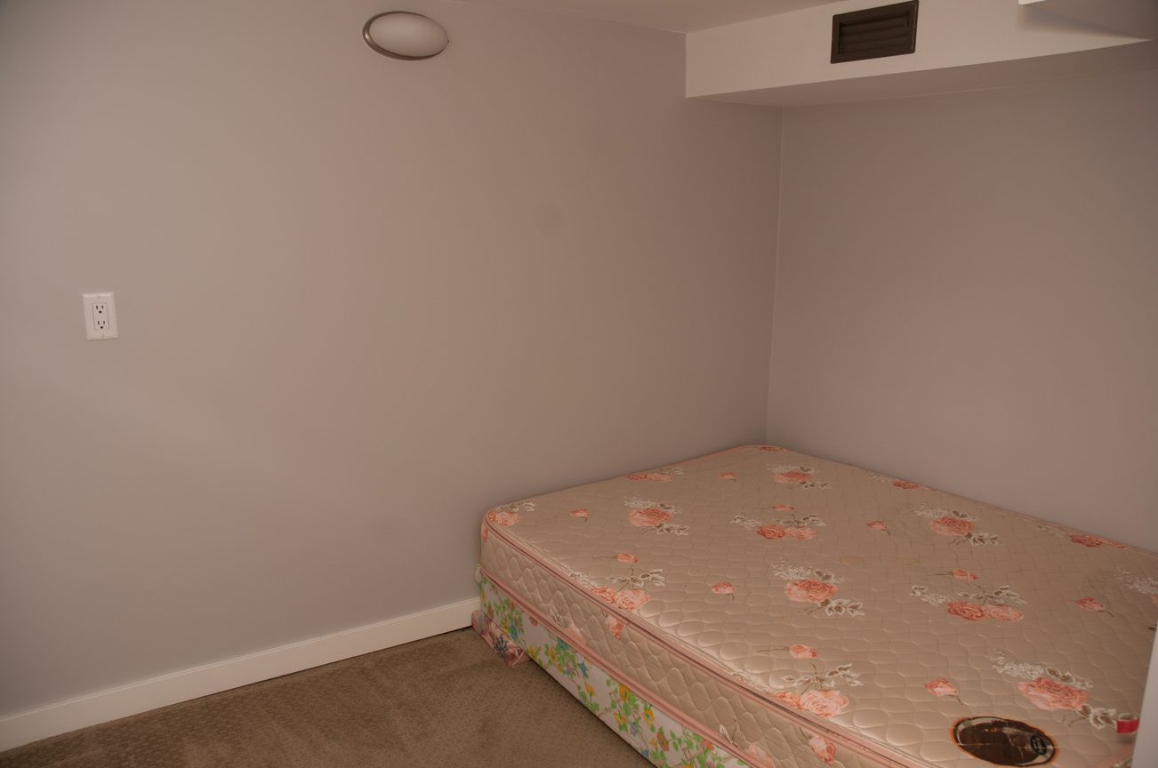 Small bedroom with floral mattress covers and carpeted floor. - 3249 West 36th Ave, Vancouver West Side