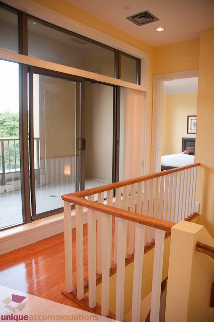 Furnished living room with hardwood floors and sliding glass doors leading to a balcony. - 103-2288 Bellevue Ave, West Vancouver