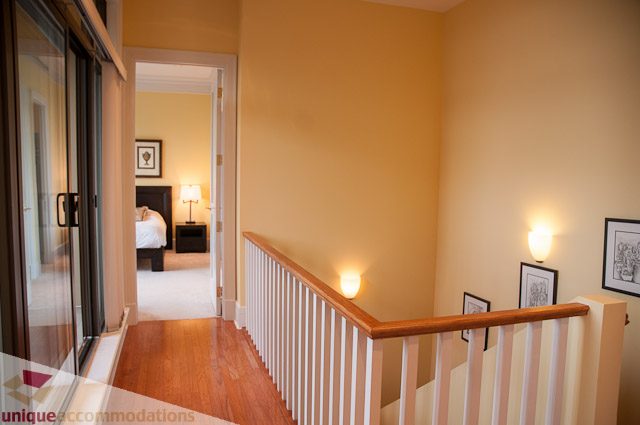 Furnished bedroom with wooden floors and a cozy ambiance. - 103-2288 Bellevue Ave, West Vancouver
