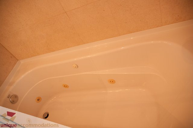 Bathroom with corner bathtub and jets. - 103-2288 Bellevue Ave, West Vancouver