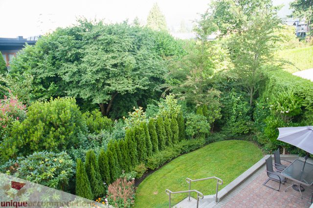 Furnished living room with lush greenery and patio seating. - 103-2288 Bellevue Ave, West Vancouver
