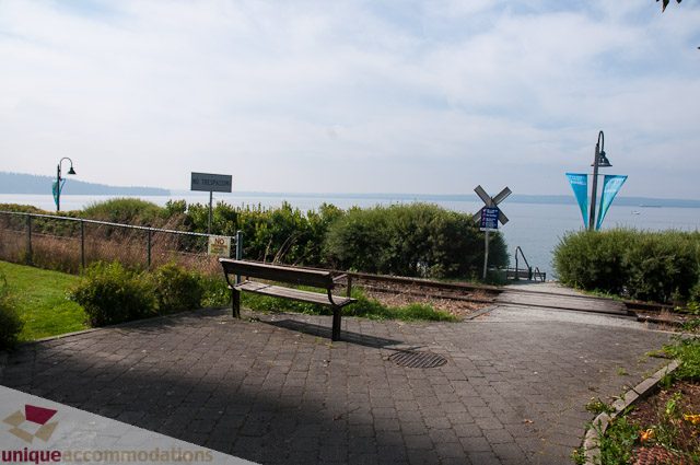 Furnished patio with water view and bench seating. - 103-2288 Bellevue Ave, West Vancouver