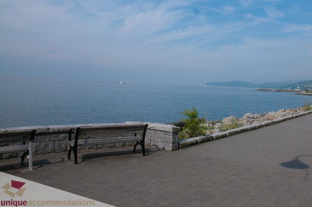 Furnished living room with ocean view and stone bench. - 103-2288 Bellevue Ave, West Vancouver