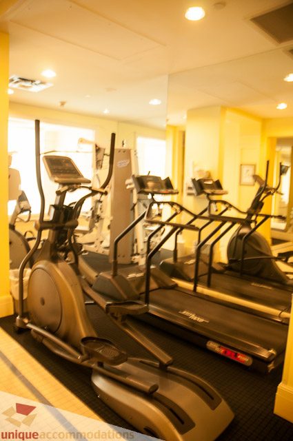Fitness room with treadmills and ellipticals, well-lit and organized. - 103-2288 Bellevue Ave, West Vancouver