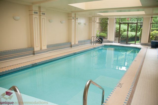 Spacious indoor pool with tiled edges and natural light. - 103-2288 Bellevue Ave, West Vancouver