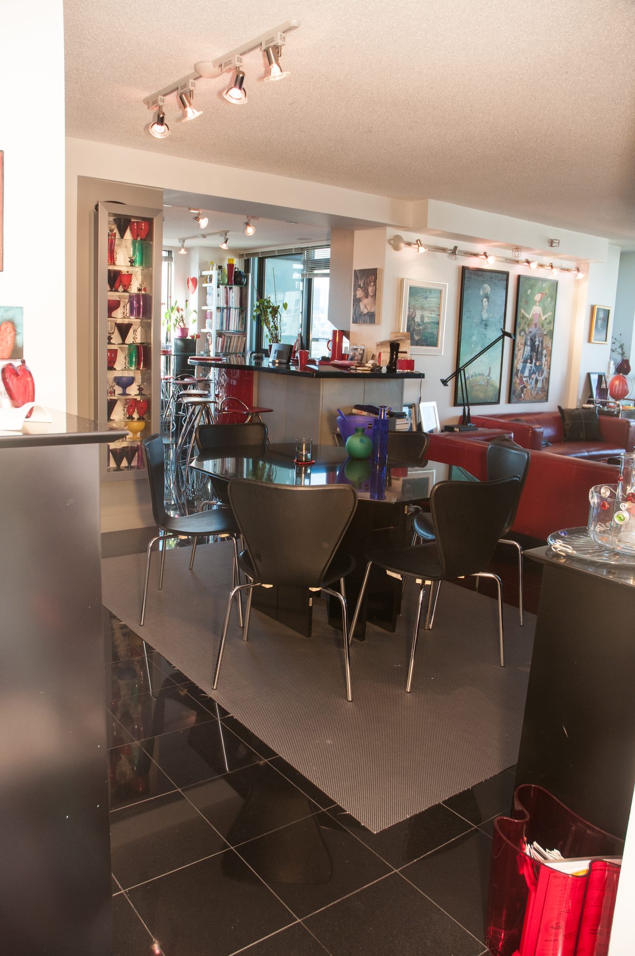 Furnished dining area with black table, chairs, and countertop; modern decor and artwork on walls. - 3201 - 1331 Alberni, Vancouver Downtown