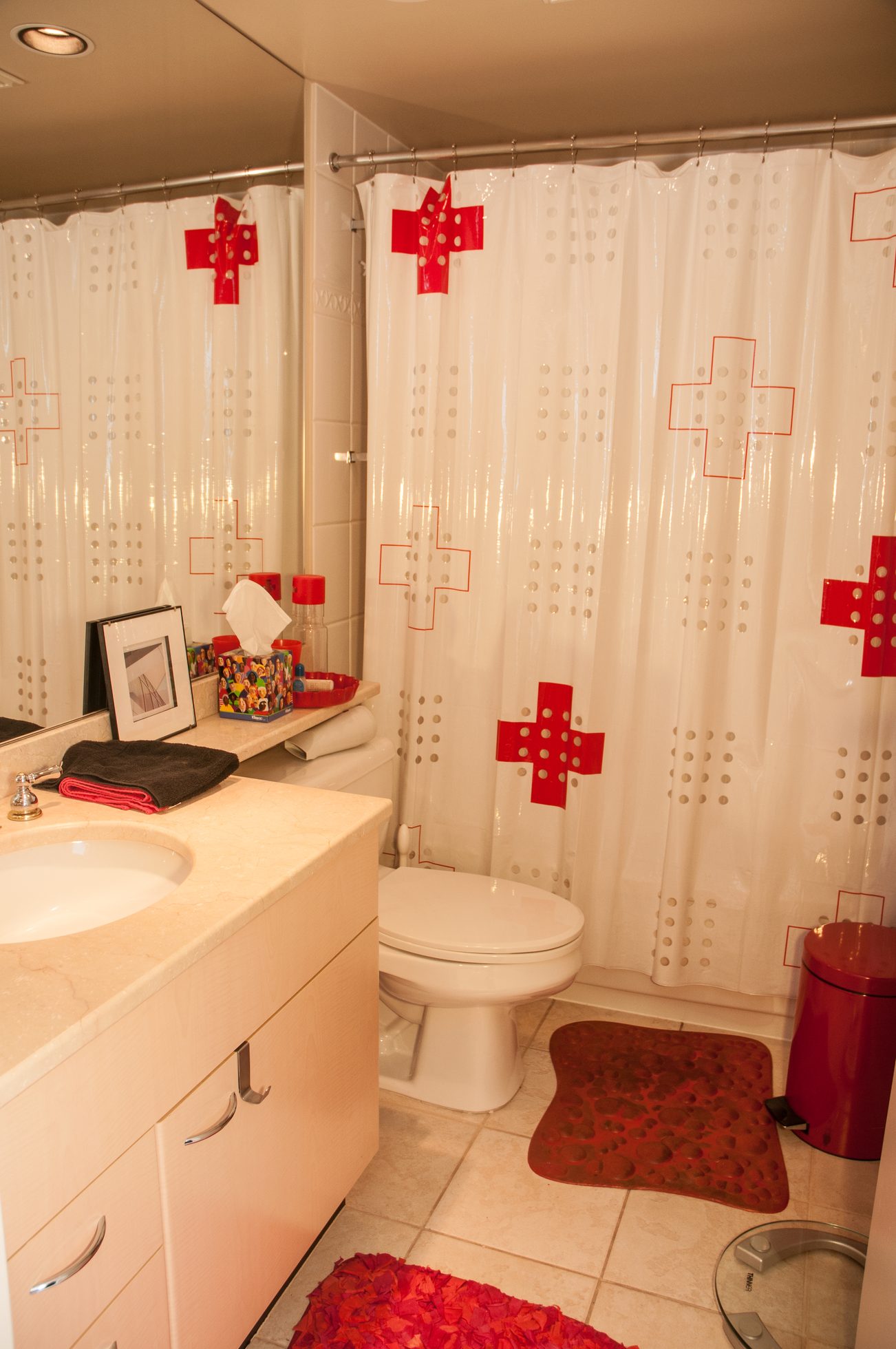 Furnished bathroom with red cross shower curtain and red bath mat. - 3201 - 1331 Alberni, Vancouver Downtown