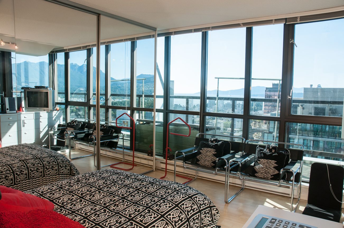Bright living room with city view and large windows, featuring a patterned sofa and modern furniture. - 3201 - 1331 Alberni, Vancouver Downtown