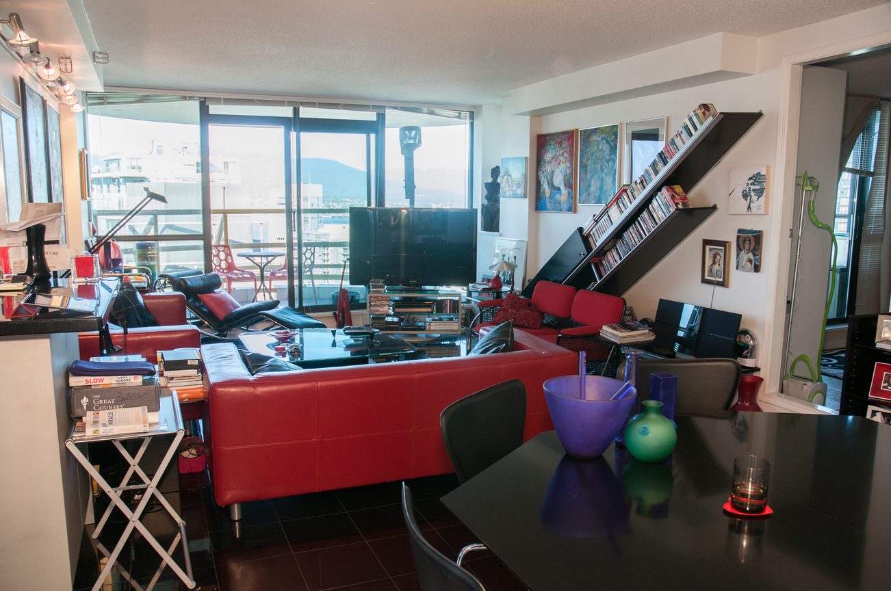 Living room with red furniture, city view, and modern decor. - 3201 - 1331 Alberni, Vancouver Downtown