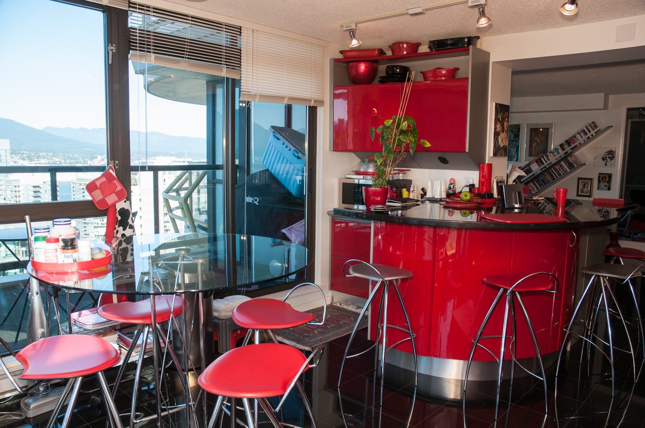 Bright kitchen with red cabinets, city view, and modern bar stools. - 3201 - 1331 Alberni, Vancouver Downtown