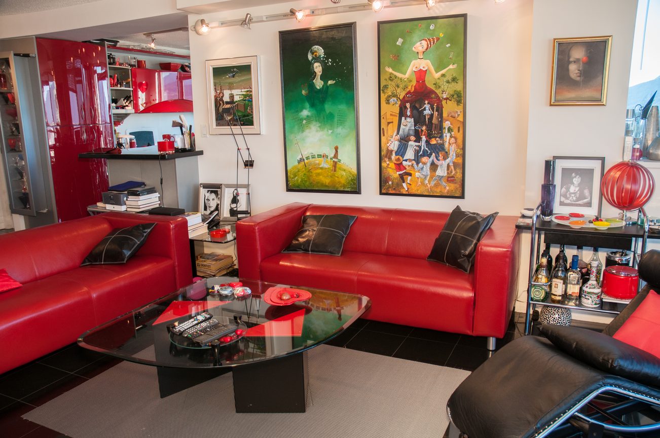 Furnished living room with red leather sofas, glass coffee table, and vibrant artwork on the walls. - 3201 - 1331 Alberni, Vancouver Downtown
