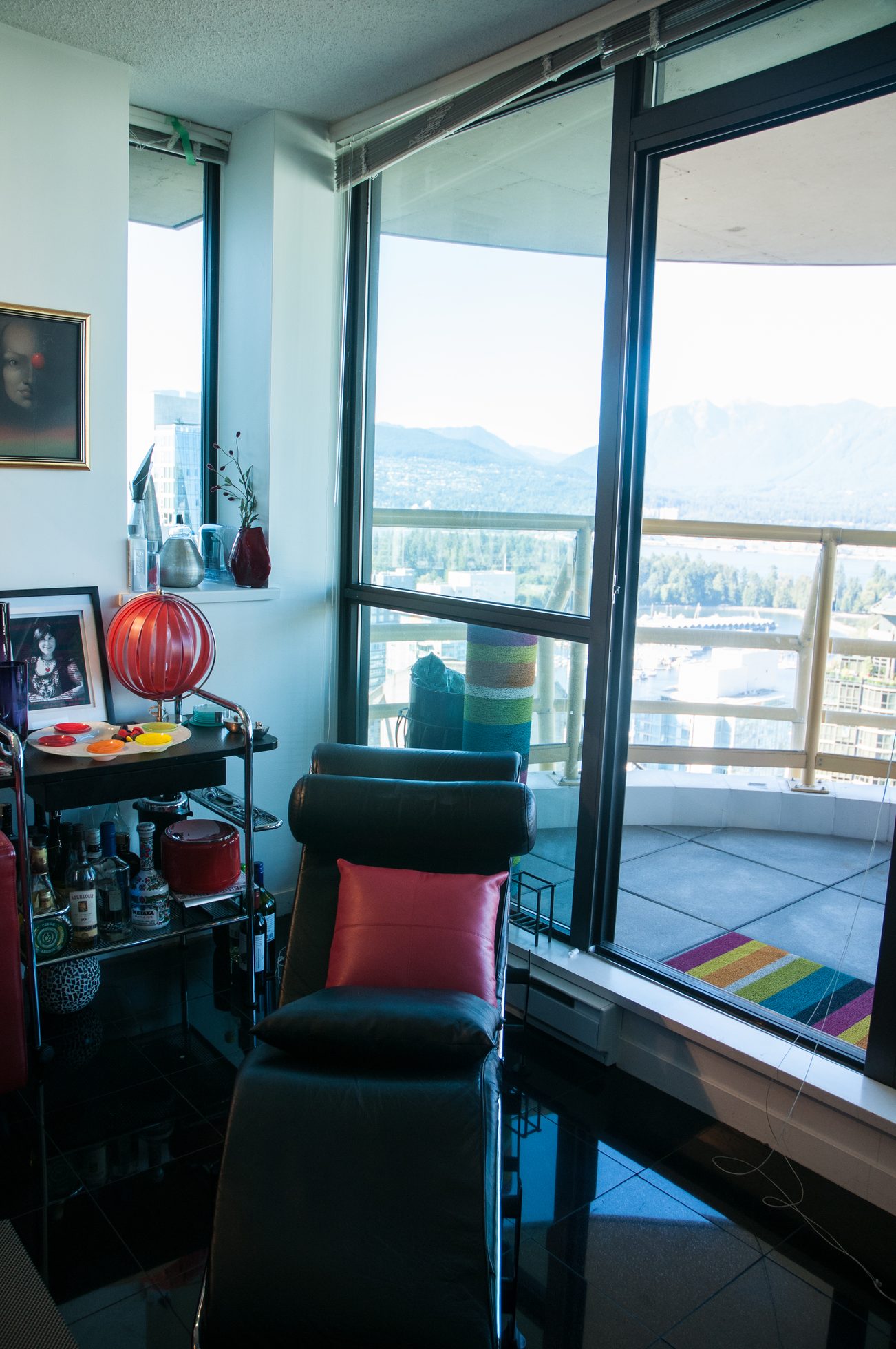 Bright living room with a city view and a red cushioned chair. - 3201 - 1331 Alberni, Vancouver Downtown