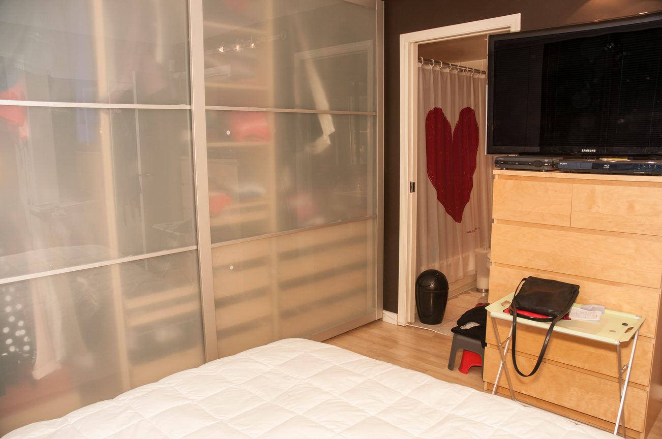 Furnished bedroom with sliding glass closet, heart on door, wooden desk, TV. - 3201 - 1331 Alberni, Vancouver Downtown