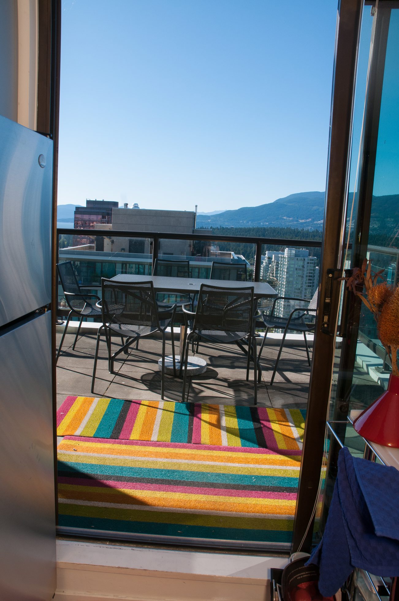 Bright balcony with colorful striped rug, city view, and modern furniture. - 3201 - 1331 Alberni, Vancouver Downtown
