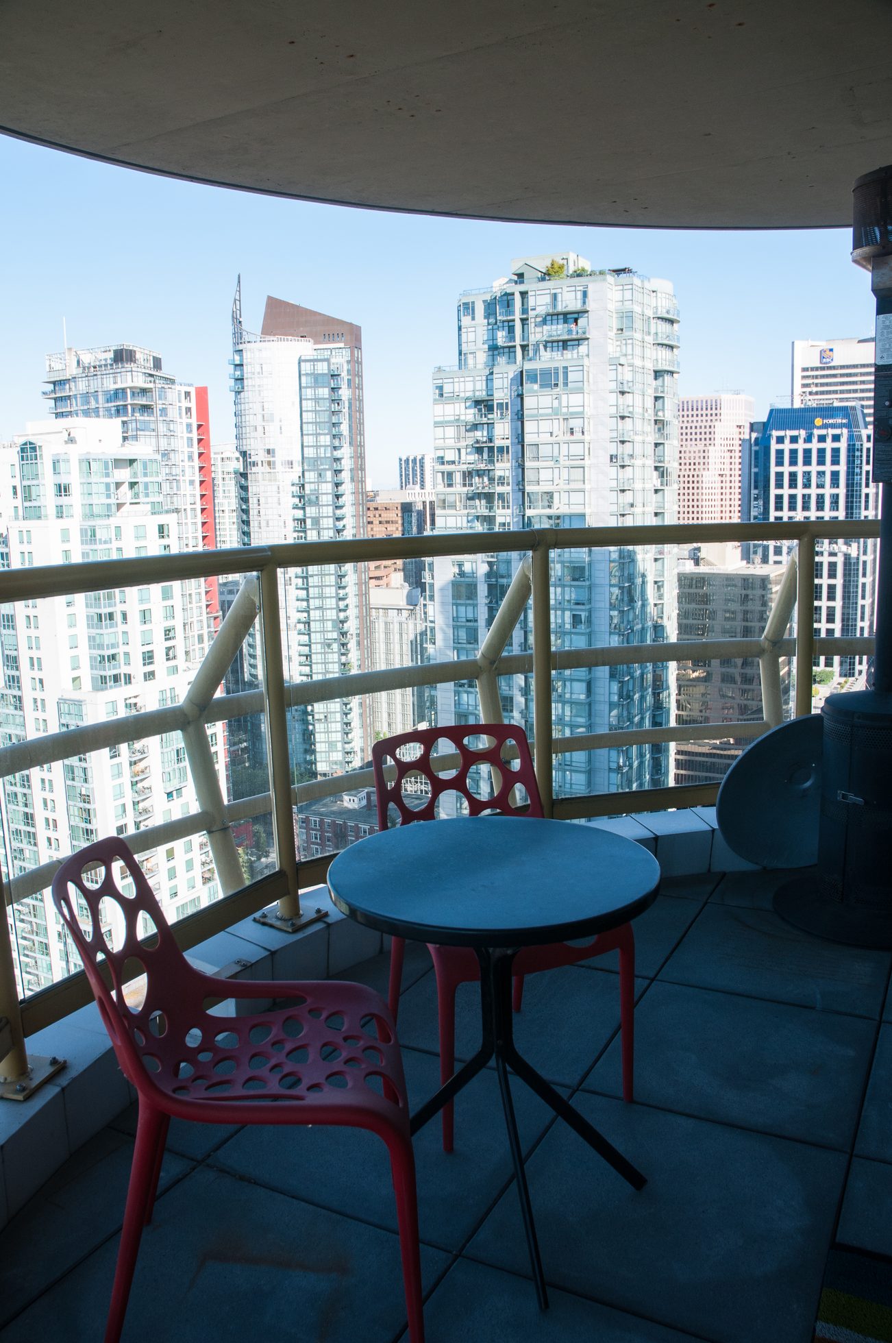 Furnished balcony with city view, red chairs, and black table. - 3201 - 1331 Alberni, Vancouver Downtown