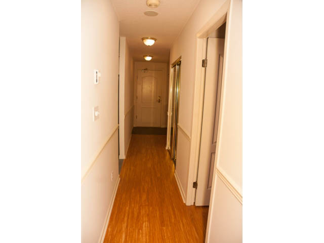 Bright hallway with hardwood floors and white walls. - 308 - 1327 East Keith Road, North Vancouver